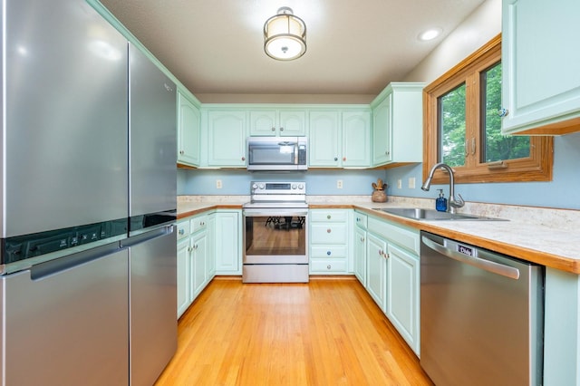 4774 Coachlight Dr, West Des Moines, IA 50265 - kitchen featuring stainless steel appliances, a sink, light countertops, light wood-type flooring, and recessed lighting