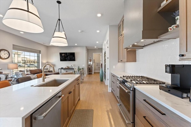 1645 SW Magazine Rd Unit 102, Ankeny, IA 50023 - kitchen with appliances with stainless steel finishes, open floor plan, wall chimney exhaust hood, light wood finished floors, and recessed lighting