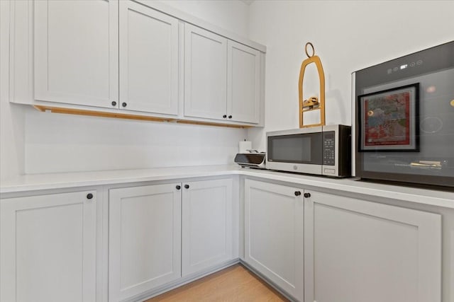 1645 SW Magazine Rd Unit 102, Ankeny, IA 50023 - kitchen with stainless steel microwave, light countertops, and light wood-type flooring