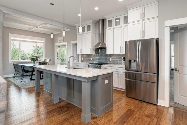 16206 Brookview Dr, Urbandale, IA 50323 - kitchen featuring appliances with stainless steel finishes, a sink, light countertops, wall chimney range hood, and a center island with sink