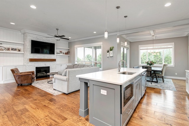 16206 Brookview Dr, Urbandale, IA 50323 - kitchen with gray cabinets, a sink, stainless steel microwave, ceiling fan, and light countertops