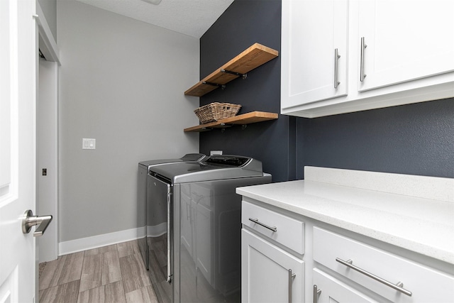 16206 Brookview Dr, Urbandale, IA 50323 - laundry room featuring washing machine and dryer, cabinet space, light wood finished floors, and baseboards