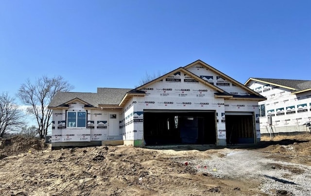 unfinished property featuring roof with shingles and an attached garage