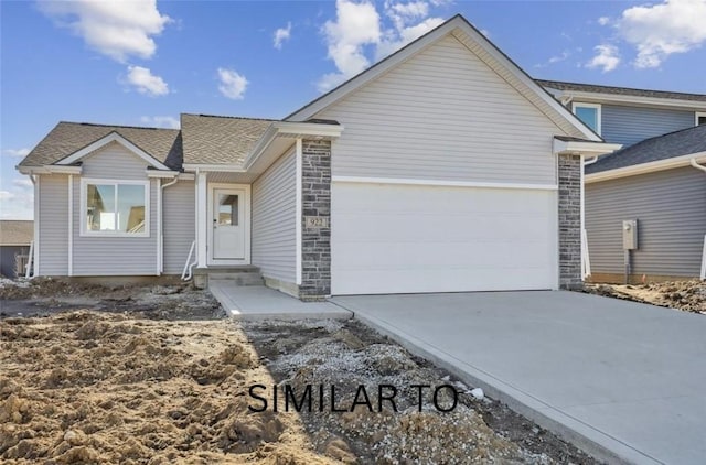 ranch-style home with stone siding, driveway, and a garage