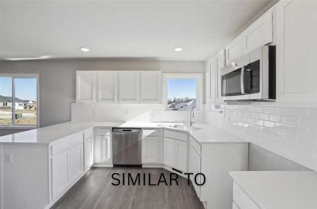kitchen with white cabinetry, a healthy amount of sunlight, a peninsula, and appliances with stainless steel finishes