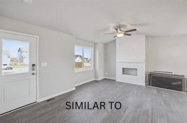 unfurnished living room featuring a fireplace, wood finished floors, lofted ceiling, visible vents, and ceiling fan