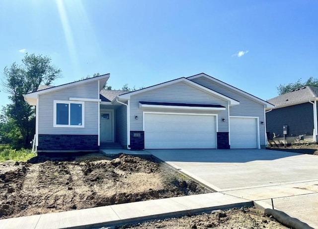 213 S Walnut Dr, Norwalk, IA 50211 - view of front facade featuring an attached garage, driveway, and brick siding
