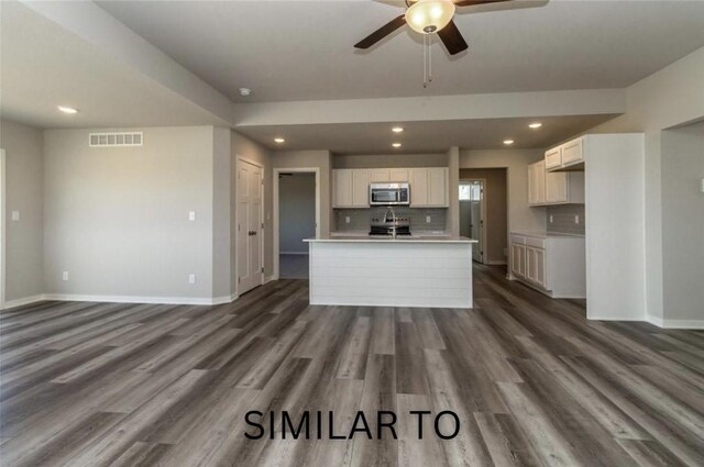 213 S Walnut Dr, Norwalk, IA 50211 - kitchen featuring stainless steel appliances, a ceiling fan, decorative backsplash, dark wood-style flooring, and white cabinetry