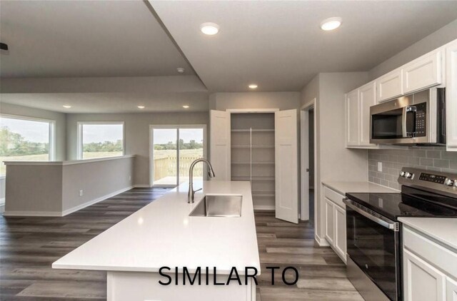 213 S Walnut Dr, Norwalk, IA 50211 - kitchen featuring stainless steel appliances, decorative backsplash, light countertops, white cabinetry, and dark wood-style floors