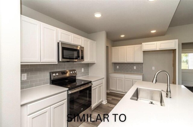 213 S Walnut Dr, Norwalk, IA 50211 - kitchen featuring stainless steel appliances, white cabinetry, recessed lighting, dark wood-style flooring, and tasteful backsplash