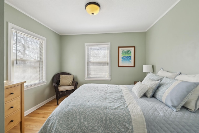 bedroom featuring light wood-style flooring, ornamental molding, and multiple windows