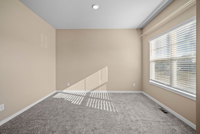empty room featuring carpet floors and baseboards