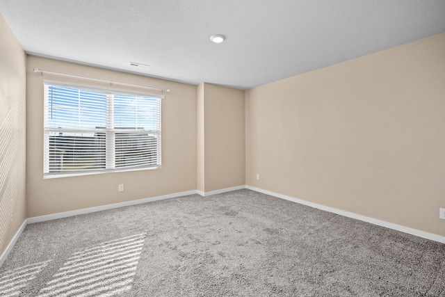 carpeted empty room featuring baseboards