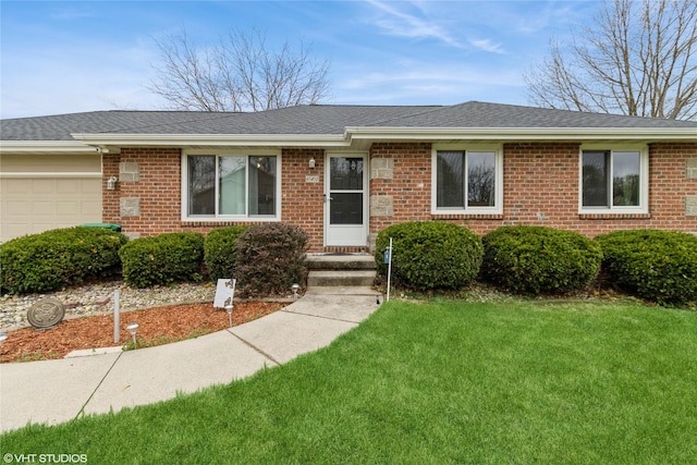 ranch-style house with brick siding, roof with shingles, a front yard, and a garage