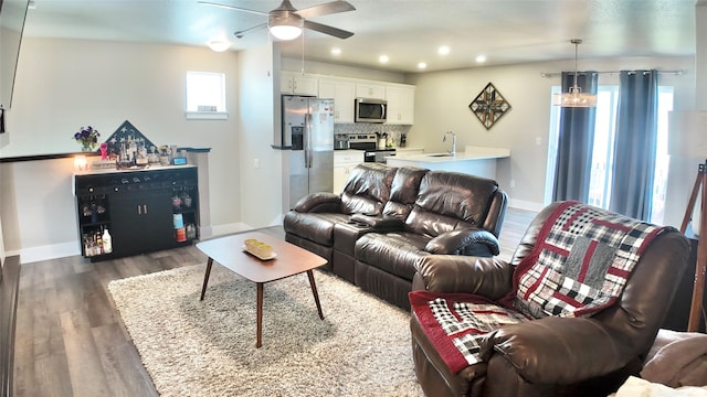 living area featuring dark wood finished floors, a ceiling fan, recessed lighting, and baseboards