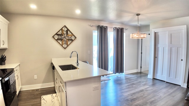 kitchen featuring a sink, baseboards, light countertops, range with electric cooktop, and dark wood-style floors