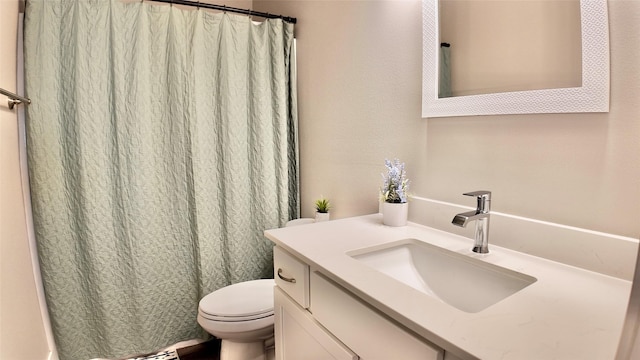 bathroom featuring toilet, a shower with shower curtain, and vanity