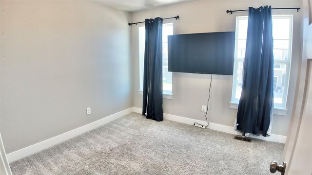 carpeted spare room with baseboards and healthy amount of natural light