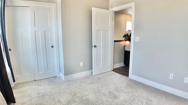 unfurnished bedroom with carpet, baseboards, and a closet