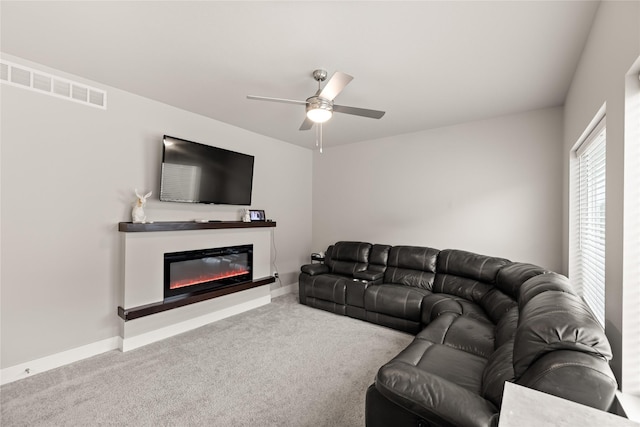 17127 Blue Sage Ln, Urbandale, IA 50323 - living area featuring carpet floors, a ceiling fan, a glass covered fireplace, and baseboards
