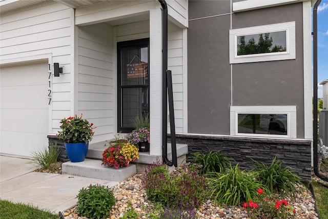 17127 Blue Sage Ln, Urbandale, IA 50323 - doorway to property featuring stone siding and a porch