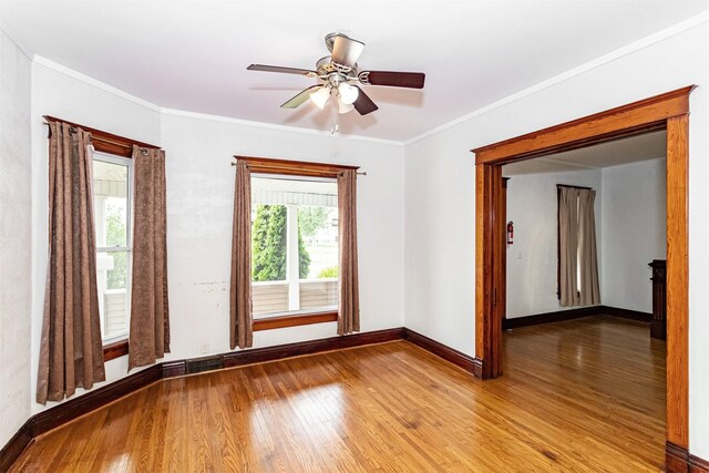 301 N 4th St, Marshalltown, IA 50158 - empty room with wood finished floors, ornamental molding, and a ceiling fan