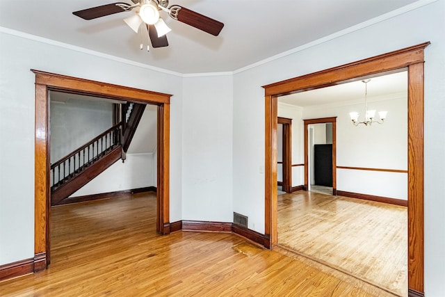301 N 4th St, Marshalltown, IA 50158 - empty room with light wood finished floors, a chandelier, stairway, ornamental molding, and ceiling fan