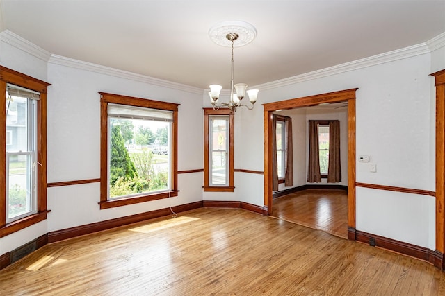 301 N 4th St, Marshalltown, IA 50158 - unfurnished room featuring a chandelier, light wood-style floors, and crown molding
