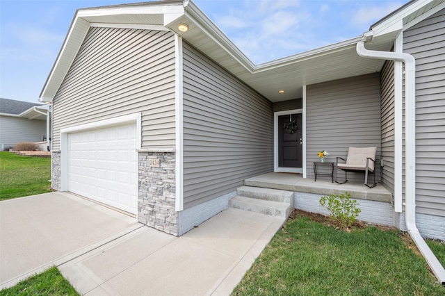 2424 N 7th Ave E, Newton, IA 50208 - doorway to property with a garage, driveway, and covered porch