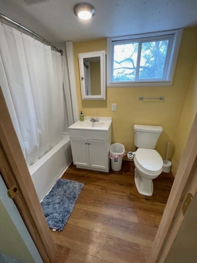 320 1st Ave, Grinnell, IA 50112 - bathroom featuring vanity, wood finished floors, shower / bath combination with curtain, and a textured ceiling