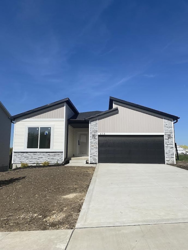 view of front of house featuring stone siding, a garage, and concrete driveway
