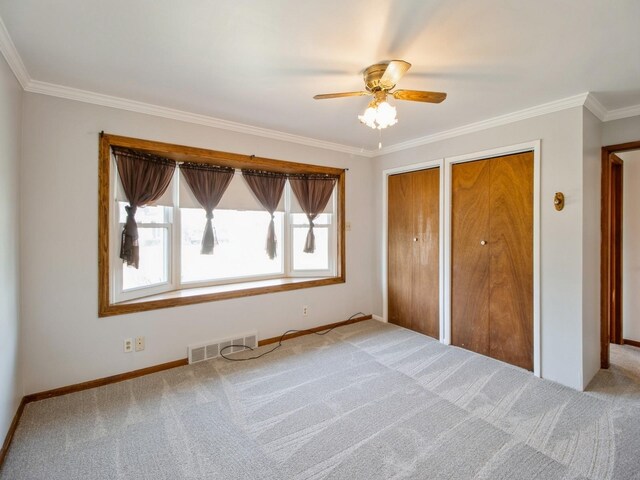 3112 Sheridan Ave, Des Moines, IA 50310 - unfurnished bedroom featuring two closets, crown molding, carpet floors, and a ceiling fan