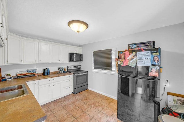 308 Pine St, Williams, IA 50271 - kitchen with white cabinetry, baseboards, black appliances, and a sink