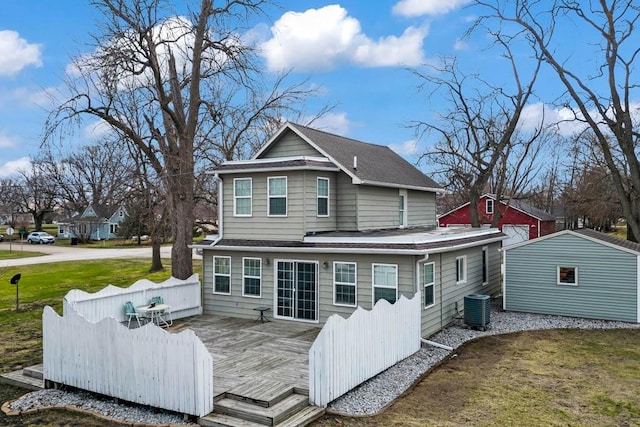 308 Pine St, Williams, IA 50271 - back of house featuring a shingled roof, a lawn, an outdoor structure, central air condition unit, and a wooden deck