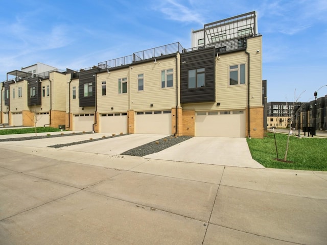 804 E 2nd St, Des Moines, IA 50309 - townhome / multi-family property with a residential view, a balcony, driveway, brick siding, and a garage