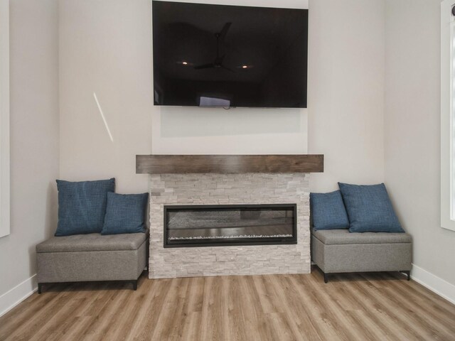 804 E 2nd St, Des Moines, IA 50309 - living area featuring a stone fireplace, baseboards, and wood finished floors