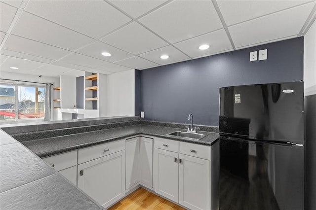 400 Coral Ridge Blvd, Pleasant Hill, IA 50327 - kitchen with white cabinets, a sink, a drop ceiling, light wood-type flooring, and freestanding refrigerator