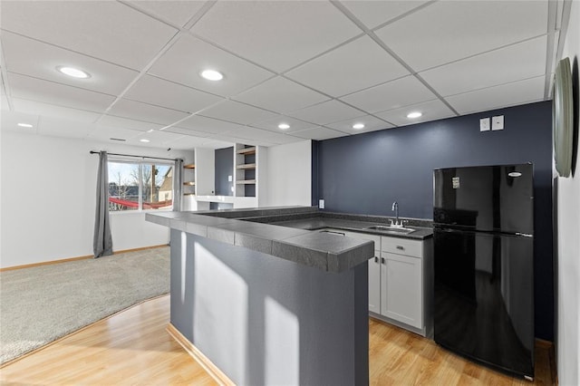 400 Coral Ridge Blvd, Pleasant Hill, IA 50327 - kitchen featuring dark countertops, a sink, light wood-type flooring, open floor plan, and freestanding refrigerator