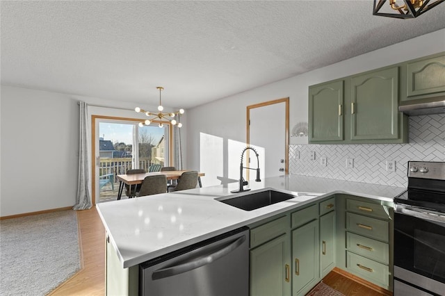 400 Coral Ridge Blvd, Pleasant Hill, IA 50327 - kitchen with green cabinets, a sink, a notable chandelier, and appliances with stainless steel finishes