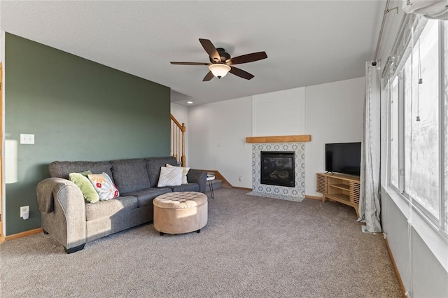 400 Coral Ridge Blvd, Pleasant Hill, IA 50327 - carpeted living room featuring baseboards, a fireplace, ceiling fan, and stairway