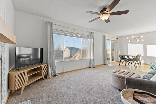 400 Coral Ridge Blvd, Pleasant Hill, IA 50327 - carpeted living area featuring ceiling fan with notable chandelier, baseboards, vaulted ceiling, and a textured ceiling