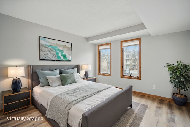 bedroom with light wood finished floors and baseboards