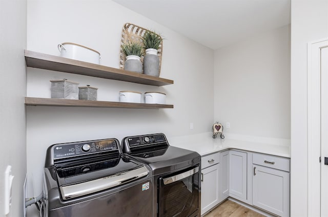 2426 SW Vineyard Ln, Ankeny, IA 50023 - laundry room with washing machine and dryer, light wood finished floors, and cabinet space