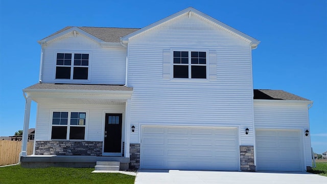 14521 Ironwood Ct, Urbandale, IA 50111 - view of front of house with concrete driveway, a garage, and stone siding