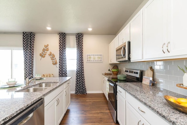 14521 Ironwood Ct, Urbandale, IA 50111 - kitchen with dark wood-style floors, white cabinets, decorative backsplash, stainless steel appliances, and a sink