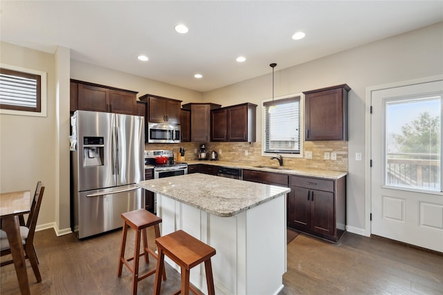 250 NE Fox Run Trl, Waukee, IA 50263 - kitchen with appliances with stainless steel finishes, a sink, tasteful backsplash, dark brown cabinets, and recessed lighting