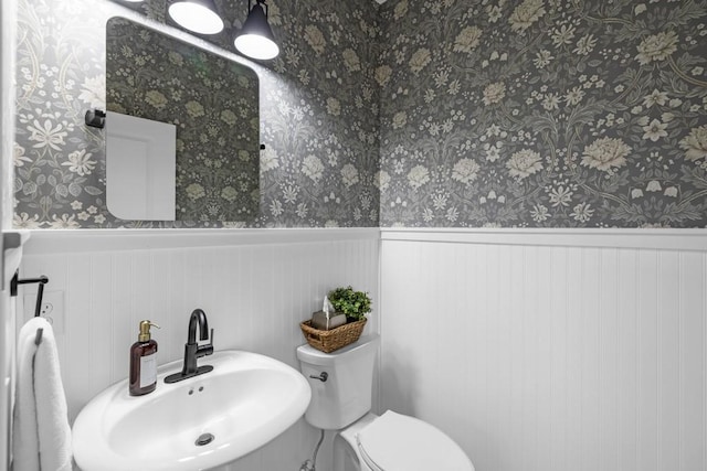2403 NE Oak Dr Unit 6, Ankeny, IA 50021 - half bath featuring wallpapered walls, toilet, a sink, and a wainscoted wall