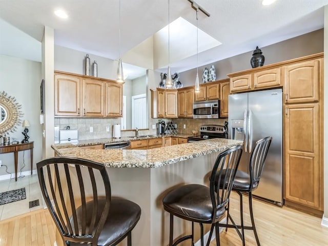 1417 NW 141st St Unit 17, Clive, IA 50325 - kitchen featuring tasteful backsplash, a breakfast bar, a sink, and appliances with stainless steel finishes