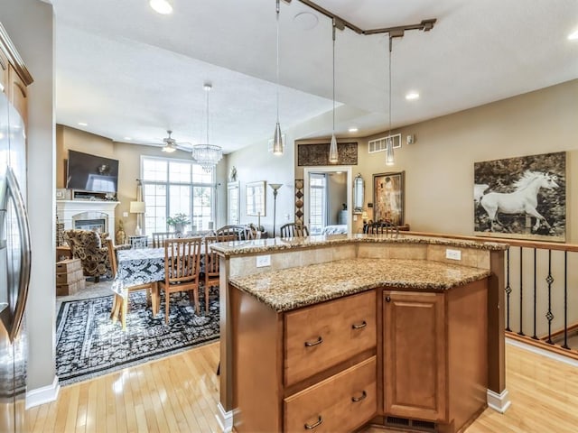 1417 NW 141st St Unit 17, Clive, IA 50325 - kitchen with light stone countertops, light wood finished floors, pendant lighting, and ceiling fan