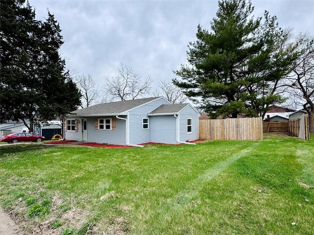 1402 E Marion St, Knoxville, IA 50138 - view of front facade with a shingled roof, fence, and a front lawn